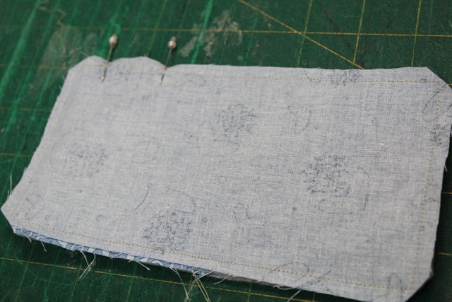 a rectangular piece of fabric with dressmaking pins - from A Quick and Simple Needlebook Tutorial by Helen of Hugs 'n Kisses