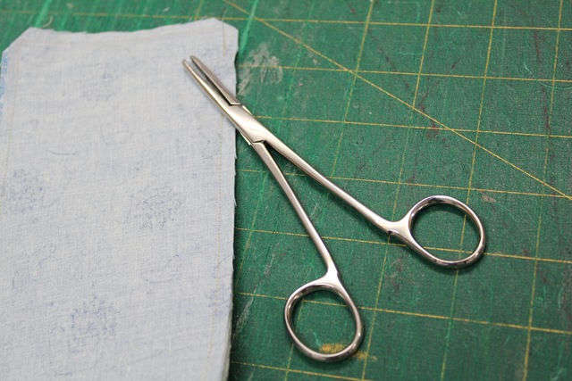 a piece of fabric and a nurse's clamps - from A Quick and Simple Needlebook Tutorial by Helen of Hugs 'n Kisses
