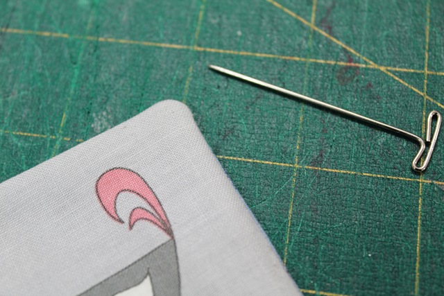 a well-pressed piece of fabric and a pin - from A Quick and Simple Needlebook Tutorial by Helen of Hugs 'n Kisses